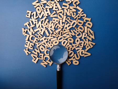 Top view magnifying glass and wooden word on a blue backgroundの写真素材