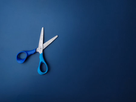 Top view blue scissors on a blue background with copy spaceの写真素材