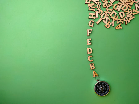 Top view wooden letter and compass with a green background with copy space.の写真素材