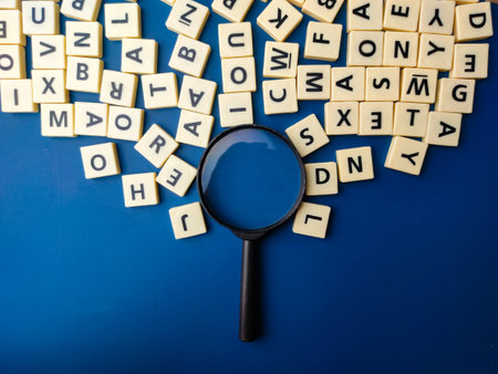 Top view magnifying glass and toys letters on a blue backgroundの写真素材