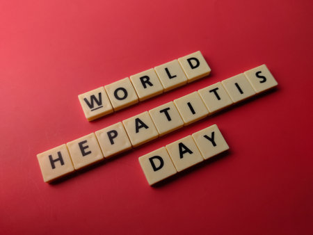Closeup toys letters with the word WORLD HEPATITIS DAY on a red backgroundの写真素材