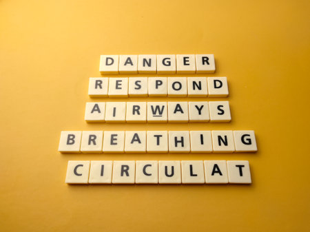 Top view toys letters with the word DANGER RESPOND AIRWAYS BREATHING CIRCULAT on a yellow background. Rescue conceptの写真素材