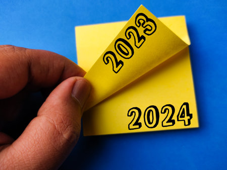 Yellow sticker note with the number 2023 2024 on a blue backgroundの写真素材