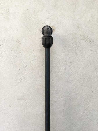 A black poly pipe installed on the outer wall of a bathroom in the area of â€‹â€‹a house.