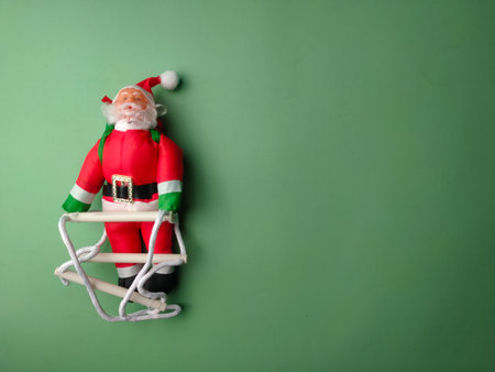 A statue of Santa Claus climbing the stairs on a green background with copy and text space.の写真素材