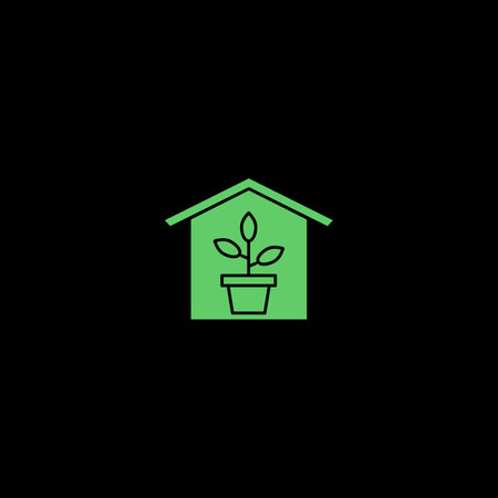 Green plant in a green small house on a black background. Green plant concept.の写真素材