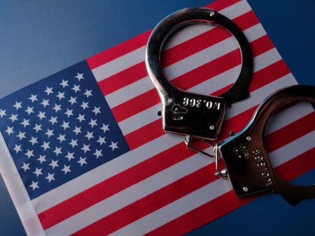Closeup america flag and hand cuff on a blue background.の写真素材