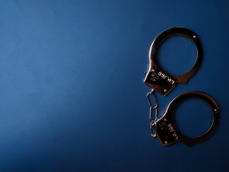 Top view hand cuff with copy and text space on a blue background.の写真素材