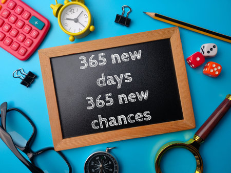 Top view wooden board with text 365 new days and new chances on a blue background. Business concept.