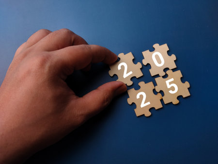 2025 on wooden puzzle with blue background, business concept.の写真素材