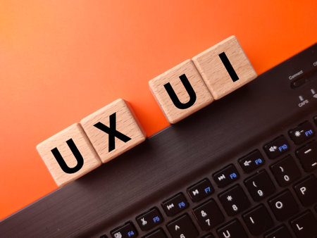 Keyboard and wooden block with the word UX UI on a orange background.User Interface and User Experience design concept.の写真素材