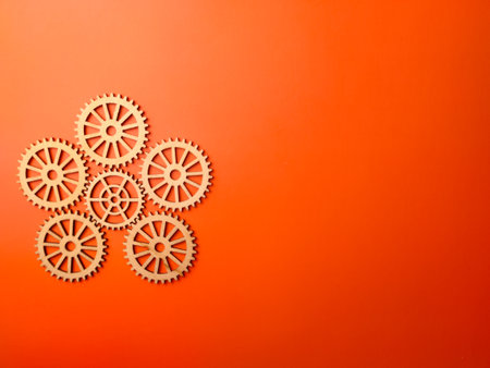 Top view of wooden gear on an orange background with copy space.の写真素材