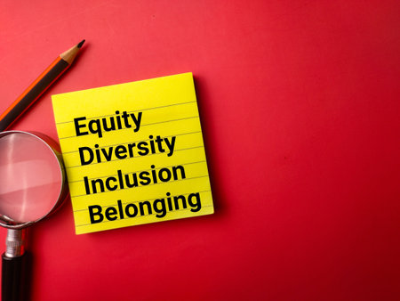 Sticky note,pencil and magnifying glass with the word Equity Diversity Inclusion Belonging on a red...