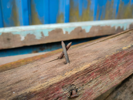 Close-up of a rusty nail sticking out of a piece of wood.の写真素材
