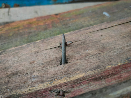 Close-up of a rusty nail sticking out of a piece of wood.の写真素材