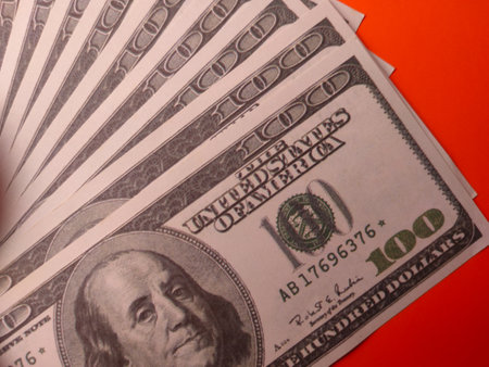 Closeup one hundred dollars on an orange background.の写真素材