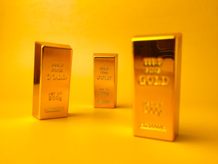 Close-up image of a three gold bars standing on a yellow background.の写真素材