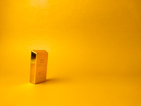 The image displays a gold bar on a yellow background with copy and text space.の写真素材