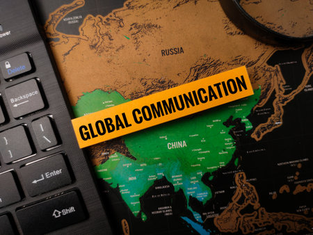 The image displays a map of Asia with the words "GLOBAL COMMUNICATION" on a yellow label, overlaid on a keyboard.の写真素材