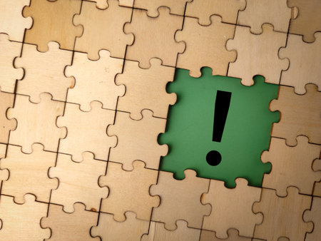 The image displays a jigsaw puzzle with a central piece featuring an exclamation mark on a green background.の写真素材