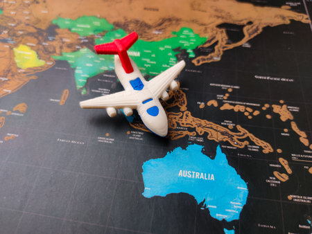 This image shows a toy airplane placed on a world map, specifically over the continent of Australia.の写真素材