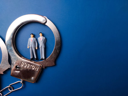 The image is a conceptual photograph featuring two miniature figurines of men in business suits...