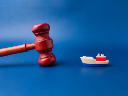 The image shows a gavel and a toy boat, which can be interpreted as a representation of maritime law or admiralty law.の写真素材