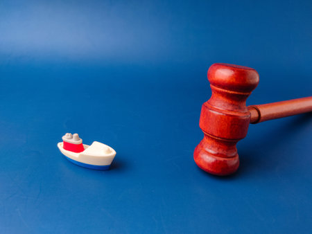 The image shows a gavel and a toy boat, which can be interpreted as a representation of maritime law...