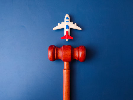 The image, which features a toy airplane next to a judge's gavel, is a visual representation of aviation law.の写真素材