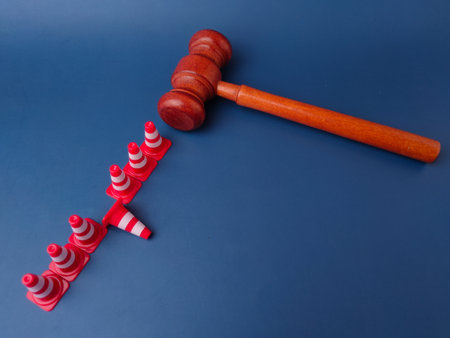 The combination of a gavel and traffic cones can symbolize legal obstacles or the law creating barriers.の写真素材