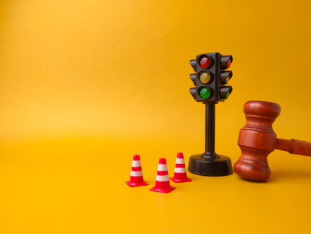 The image shows a miniature traffic light, small traffic cones, and a gavel. This combination of objects can be interpreted as a representation of traffic law and its enforcement.の写真素材