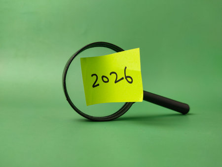 The image shows a magnifying focusing glass on a yellow sticky note with the year 2026 written on...