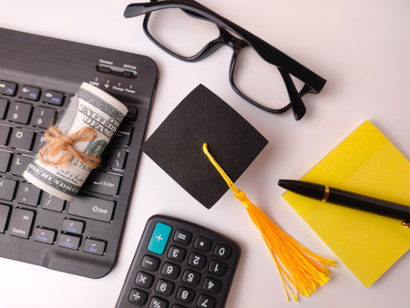 The image is a flat lay composition symbolizing the cost of education, student loans, or financing a degree.の写真素材