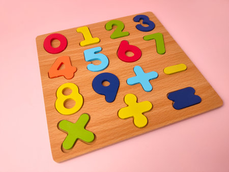 This is aÂ wooden number learning boardÂ or puzzle on a pink background.