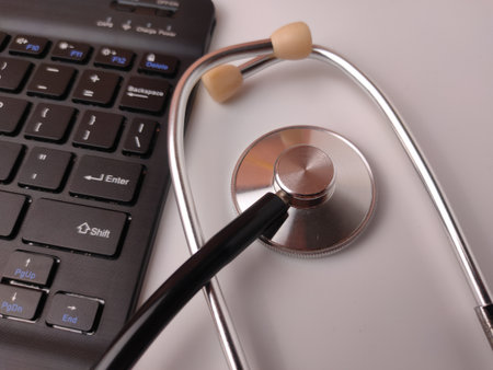 The image displays a stethoscope resting on a black computer keyboard.の写真素材