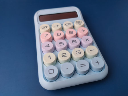 Top view pastel-colored desktop calculator featuring a retro typewriter style with large, round...