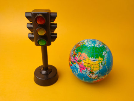 This image features aÂ toy traffic lightÂ alongside aÂ small globe.