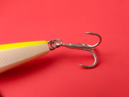 The item in the image is a fishing lure on a red background.の写真素材