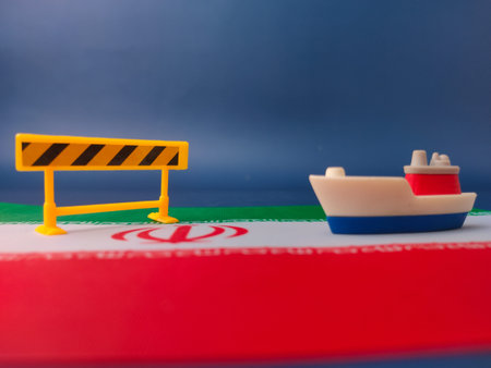 A toy ship facing a yellow construction barrier with iran flag on a blue background.