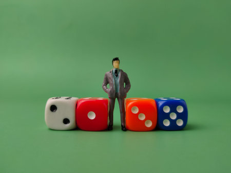 This image features a miniature figurine of a businessman standing between on of colorful dice.