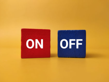 A red wooden block with text ON sits adjacent to a blue wooden block with text OFF against yellow.