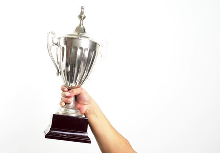 hand holding up a trophy cup as a winner in a competition
