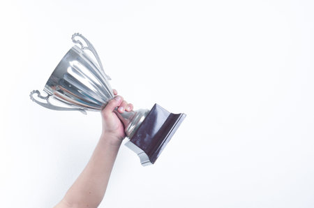hand holding up a trophy cup as a winner in a competition