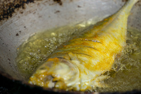 Frying a fish. Hygiene in food preparation is crucial.
