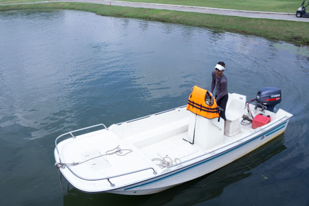 Kuala Lumpur, Malaysia - October 31, 2015 A man on the boat at golf course's lake.