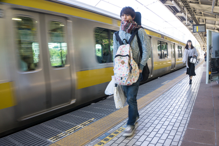 Tokyo, Japan Ã¢ï¿½ï¿½ Nov 6, 2016. Rail transport in Japan is a major passenger transport, mass and high-speed travel between cities and within metropolitan areas. People are walking besides moving train.のeditorial素材