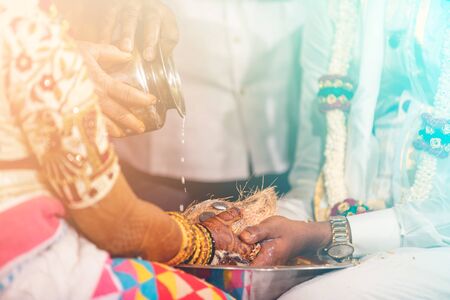 south indian bride and groom holding coconut. milk pouring ritualの写真素材