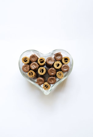 pastries with chocolate in a glass box, against white backgroundの写真素材
