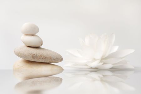 wellness still life pebbles and white lily, reflection in water, with waves,high key studio shotの写真素材