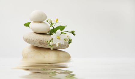 wellness still life pebbles and white jasmine,reflection in water, high key studio shotの写真素材